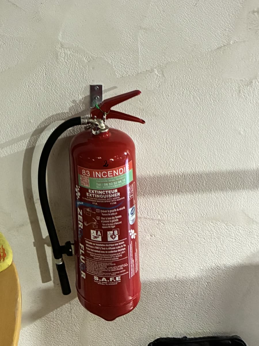 Extincteur à eau avec additif, étiqueté 83 incendie, sur son support mural